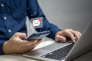 Businessman checks email on his phone shown by email icon