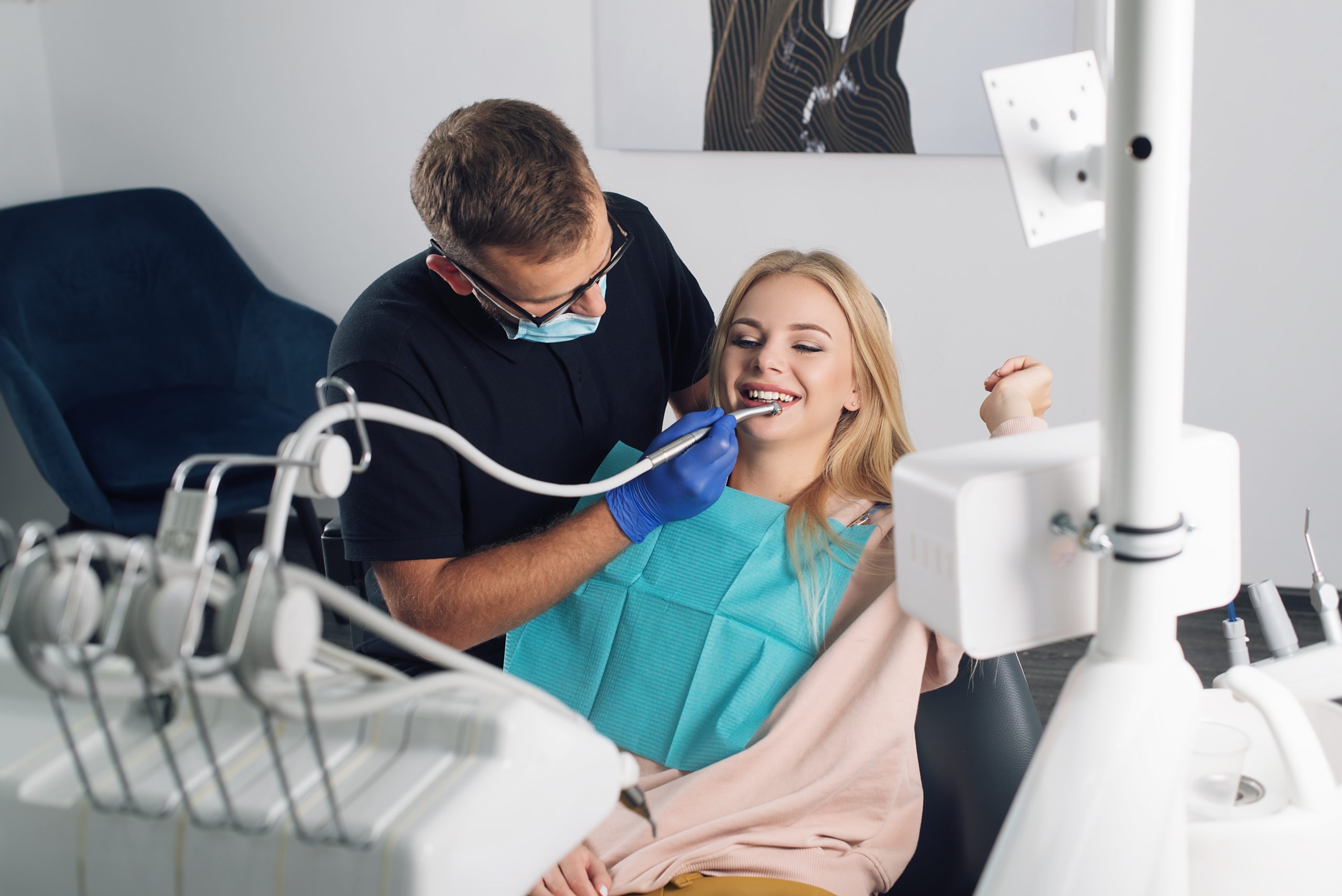 A male dental SEO client performs a dental exam on a female patient 